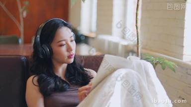 年轻<strong>女人</strong>在家看书听音乐